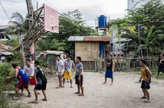Men shoot hoops in the Visayan Region of the Philippines
