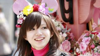 Mujer con orejas de Minnie en Tokyo.