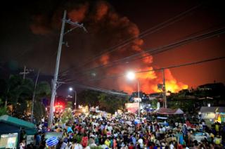 People go out in the streets with their belongings after a fire engulfed shanties at a community of informal settlers in Catmon