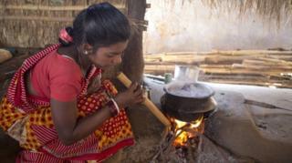 కట్టెల పోయి ఊదుతున్న మహిళ