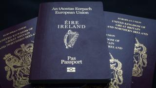 An Irish passport is seen on a pile of UK passports