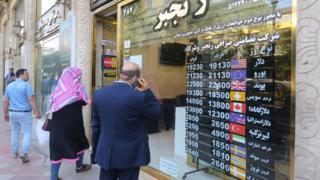 Iranians wait outside a money exchange office in Tehran amid the ongoing COVID-19 pandemic, on June 22, 2020