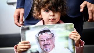 Mtoto mdogoakishikilia picha ya mwanahabari wa Saudi Arabia Jamal Khashoggi