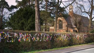 Wool message in hedgerow
