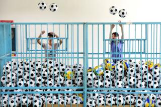 Employees sort footballs at a company manufacturing sports equipment, in Yiwu, Zhejiang province, China, 5 July 2018