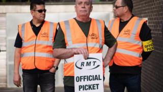 Rail workers form a picket line at Euston Station in London