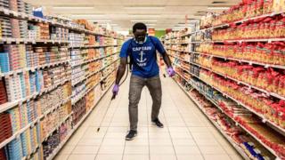 A man is disinfects a empty supermarket in Dakar on May 11, 2020. - Big supermarkets are being closed down on specific days for a few weeks in order to disinfect them against the spread of the COVID-19 coronavirus.