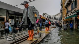 People walk in temporary aisles in Venice on October 29, 2018