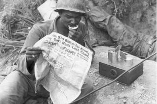 A soldier reads Star and Stripes during a lull in fighting in Korea in 1952