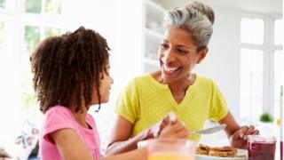 Woman and girl eating breakfast