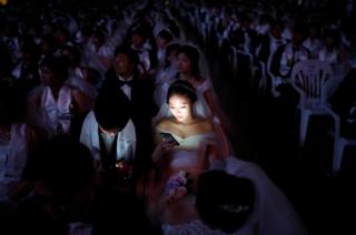 Couples attend a mass wedding ceremony of the Unification Church