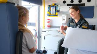 Ambulance worker speaking to child in ambulance