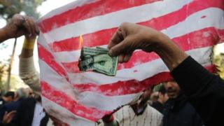 Iranian protester burns US bank note