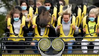 People in masks on a rollercoaster at Alton Towers on the first day of reopening after lockdown