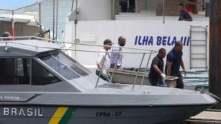 The body of one of the victims of a boat wreck, after a ferry sank off the north-eastern state of Bahia, is loaded at the Maritime Terminal of Salvador, Bahia State, on August 24, 2017.