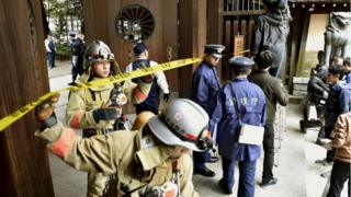 Police officers and fire fighters at the south gate of the Yasukuni shrine