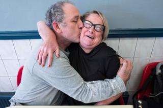 A couple embrace and kiss