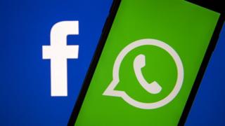 The Facebook and WhatsApp logos are seen on a phone in this photo illustration