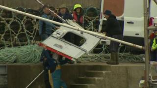 A panel from the helicopter is brought ashore