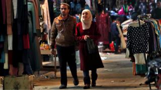 زوجان في يسيران في سوق في سوريا