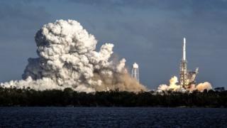 The space rocket is seen launching, surrounded by plumes of smoke at its base