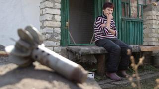 Жінка на зруйнованому подвір'ї, Луганська область