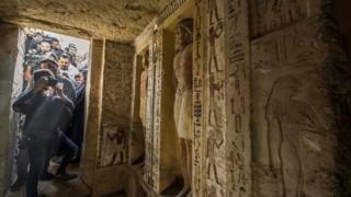 Journalists enter a newly-discovered tomb at the Saqqara necropolis, 30 kilometres south of the Egyptian capital Cairo