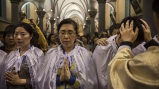 Chinese Catholic Bishop Zhang Hong, right, blesses newly baptized worshippers during a special ceremony at a mass on Holy Saturday during Easter celebrations at the government sanctioned West Beijing Catholic Church on April 15, 2017 in Beijing, China. China, an officially atheist country, places a number of restrictions on Christians, allowing legal practice of the faith only at state-approved churches.