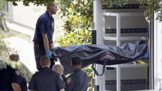 Officials remove a body from a house in Houston. Photo: 9 August 2015