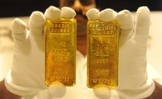 A jewellery shop employee displays 24-carat gold bars
