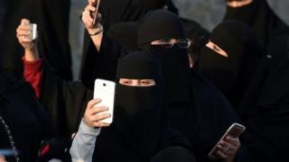 Мобиль телефонларида фотосурат олаётган саудиялик аёллар