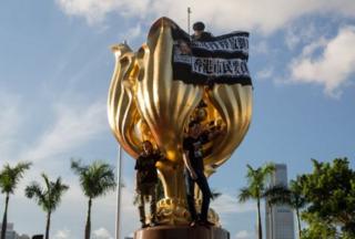ผู้ประท้วงบางส่วนล่ามตัวเองเข้ากับประติมากรรม เมื่อคืนวันพุธ (28 มิ.ย.)