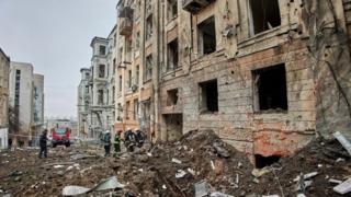 Ukrainian rescuers work at the site of a damaged residential building following a missile strike, in Kharkiv, northeastern Ukraine, 05 February 2023