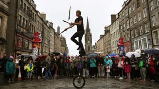 Street performer juggling knives and fire on the Royal Mile