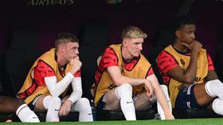 Cole Palmer and Anthony Gordon of England look on as they sit on the substitutes bench during the UEFA EURO 2024 group stage match between Denmark and England at Frankfurt Arena