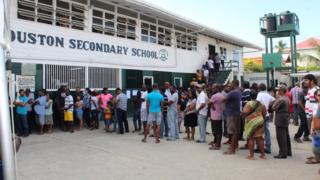 People in Georgetown, Guyana, wait in a queue to cast their vote