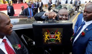 Kenya's Finance Minister Henry Rotich holds up a briefcase