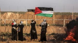 نساء فلسطينيات يحملن العلم الفلسطيني