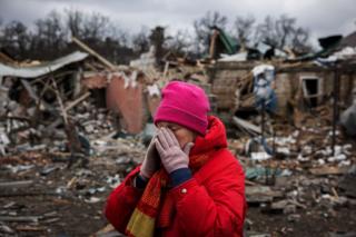 Женщина у разрушенных домов в Украине 
