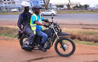 Mwendeshaji pikipiki akiwa amembeba abiria