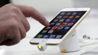 Мужчина тестирует мобильный телефон iPhone 6 от Apple в магазине в Мюнхене, Германия, 27 января 2016 года.