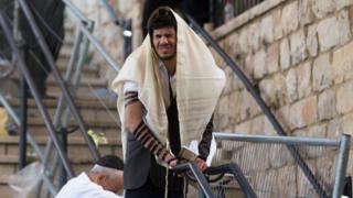 Image shows a man praying after the disaster