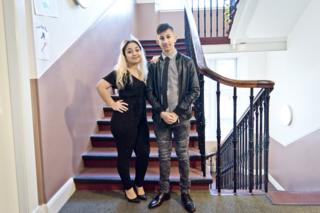Two teenagers standing on the staircase