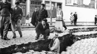 Hombres entre las grietas causadas en el suelo en el terremoto de Valdivia, Chile, en 1960