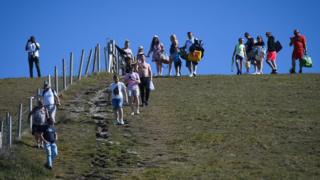 Touristen machen sich auf den Weg zum Durdle Door Strand in Dorset