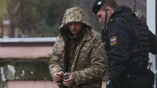   A Ukrainian sailor led by a Russian security officer 