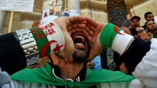 Algerian protestors shout slogans during a demonstration.