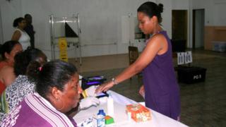 A woman gives her fingerprint after voting at a polling station in Victoria, Seychelles, on 10 September 016