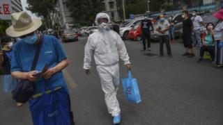 Медицинский работник в Пекине держит синюю сумку для переноски