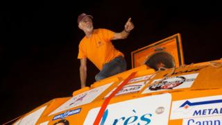 Jean-Jacques Savin is seen on top of his custom-made barrel after landing on the French Caribbean island of Martinique